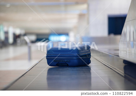 Lonely blue suitcase on baggage claim at airport. 110822594