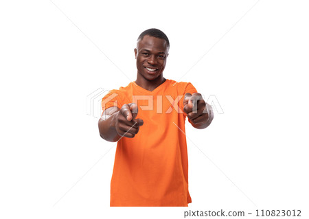 young successful charismatic american man dressed in basic orange t-shirt points with index finger young successful charismatic american man dressed in basic orange t-shirt points with index finger 110823012