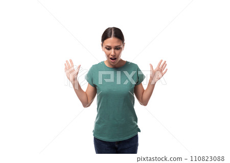 pretty young caucasian brunette woman in green t-shirt raised her hands in surprise pretty young caucasian brunette woman in green t-shirt raised her hands in surprise 110823088