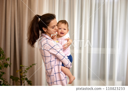 loving mother hugs her little crying daughter at home loving mother hugs her little crying daughter at home 110823233