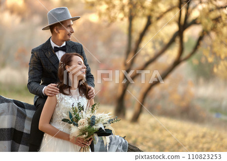 beautiful happy stylish bride and groom in hat near tree in autumn beautiful happy stylish bride and groom in hat near tree in autumn 110823253