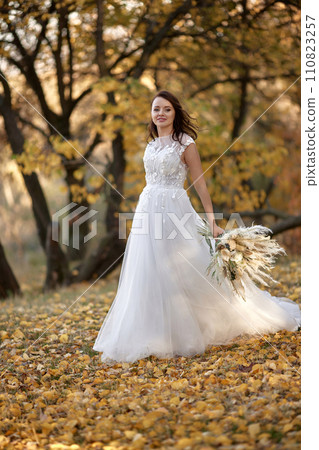 beautiful happy bride holding wedding autumn bouquet in nature 110823257