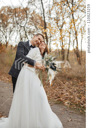 smiling bride and groom enjoying romantic moments outside in autumn smiling bride and groom enjoying romantic moments outside in autumn 110823259