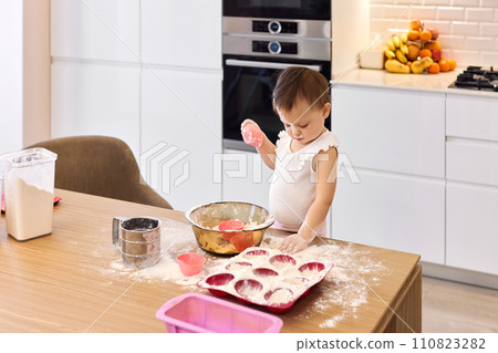 little baby girl preparing the dough in the kitchen, child cooking cookies. little baby girl preparing the dough in the kitchen, child cooking cookies. 110823282