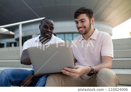 Two colleagues working together remotely and looking involved 110824006