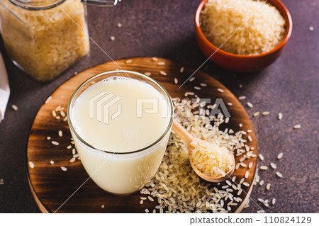Alternative healthy rice milk in a glass and rice cereal on the table Alternative healthy rice milk in a glass and rice cereal on the table 110824129