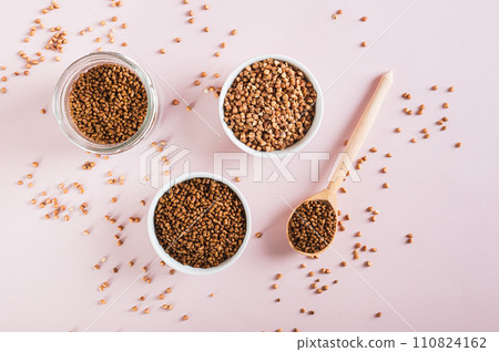 Dry buckwheat tea granules in a bowl, spoon and jar on the table top view Dry buckwheat tea granules in a bowl, spoon and jar on the table top view 110824162