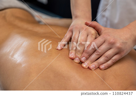 Close up of massage therapist hands doing back massage Close up of massage therapist hands doing back massage 110824437