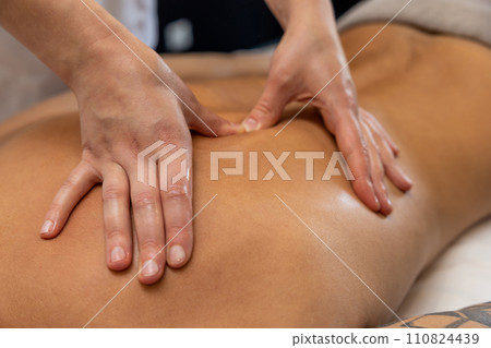 Close up of massage therapist hands doing back massage Close up of massage therapist hands doing back massage 110824439