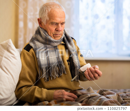 Elderly Senor measuring pressure with tonometer at Home 110825797