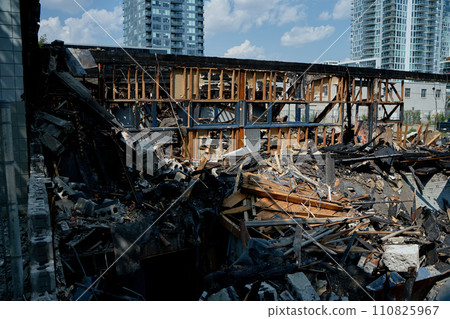 A burnt-out old wooden building after a fire. Charred beams after the destruction. 110825967