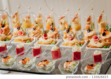 Assortment of delicious snacks on the open buffet festive table in restaurant. Catering plate 110826815