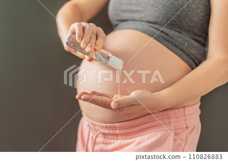 Expectant mom ensures safety, applying gel sanitizer for a clean and healthy pregnancy Expectant mom ensures safety, applying gel sanitizer for a clean and healthy pregnancy 110826883
