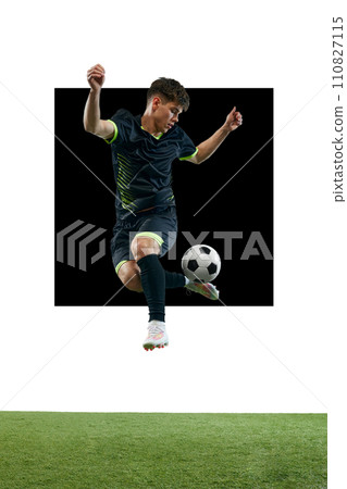 Young man in black uniform, soccer playing in motion with ball, playing isolated over white background with grass flooring. Poster Young man in black uniform, soccer playing in motion with ball, playing isolated over white background with grass flooring. Poster 110827115