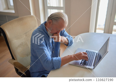 Serious mature older man client sits on couch in room talking on video call using laptop complain about bad service product. Senior aged businessman talk at online conference. Shooting in slow motion. 110827190