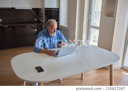 Serious mature older man client sits on couch in room talking on video call using laptop complain about bad service product. Senior aged businessman talk at online conference. Shooting in slow motion. 110827267