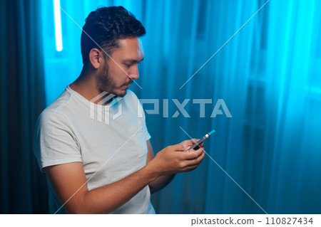 Portrait of a cheerful man using smart phone at home office. 110827434