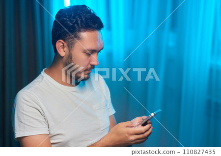 Portrait of a cheerful man using smart phone at home office. Portrait of a cheerful man using smart phone at home office. 110827435