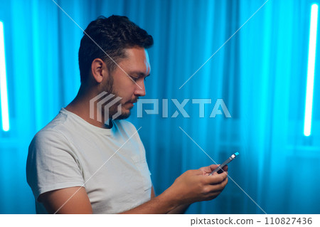 Portrait of a cheerful man using smart phone at home office. Portrait of a cheerful man using smart phone at home office. 110827436