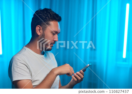 Portrait of a cheerful man using smart phone at home office. Portrait of a cheerful man using smart phone at home office. 110827437
