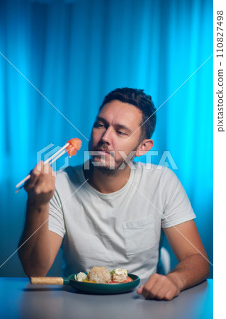 Unrecognizable man eating poke bowl with salmon,avocado,seaweed 110827498
