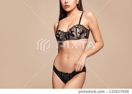 Confident beautiful young asian woman posing in black lingerie on beige background, Perfect body, Confident beautiful young asian woman posing in black lingerie on beige background, Perfect body, 110827698