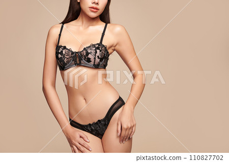 Confident beautiful young asian woman posing in black lingerie on beige background, Perfect body, Confident beautiful young asian woman posing in black lingerie on beige background, Perfect body, 110827702