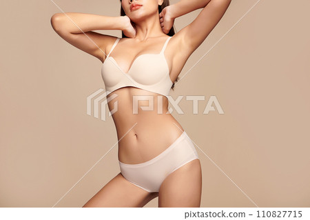 Confident beautiful young asian woman posing in white lingerie on beige background, Perfect body, Confident beautiful young asian woman posing in white lingerie on beige background, Perfect body, 110827715