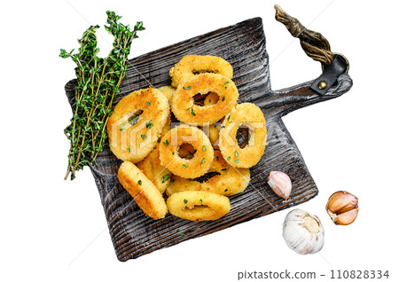 Deep fried squid calamari rings breaded on a cutting board. Isolated on white background, Top view. Deep fried squid calamari rings breaded on a cutting board. Isolated on white background, Top view. 110828334