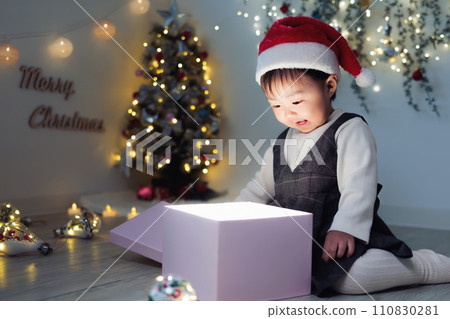 Infant opening Christmas presents, 1 year old 110830281