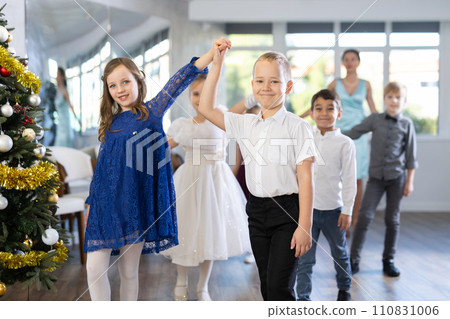 Christmas ball - beautifully dressed children dance the Viennese waltz near New Year tree 110831006