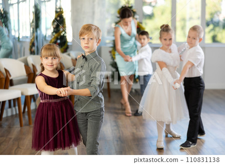 Little children practicing waltz dance in school-hall decorated with Christmas-tree Little children practicing waltz dance in school-hall decorated with Christmas-tree 110831138