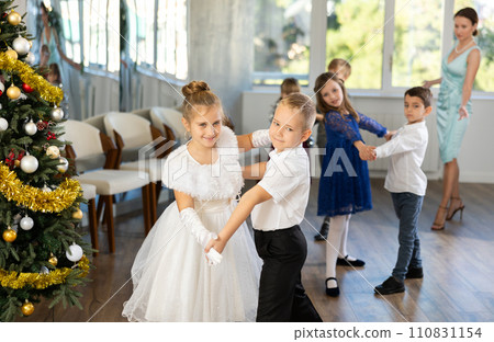 Christmas ball - group of preteen children in festive clothes dances a foxtrot near New Year tree 110831154