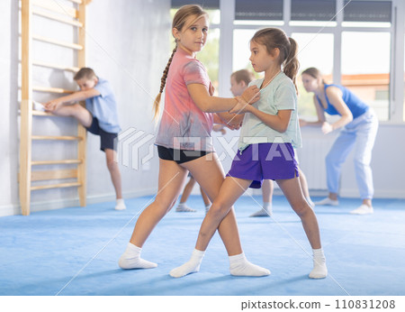 Boys and girls in gym perform basic elements of krav maga self-defense system. Boys and girls in gym perform basic elements of krav maga self-defense system. 110831208