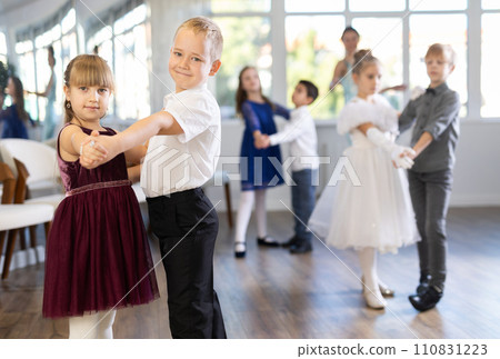 Enthusiastic preteen children dancing waltz in pairs in dance school Enthusiastic preteen children dancing waltz in pairs in dance school 110831223