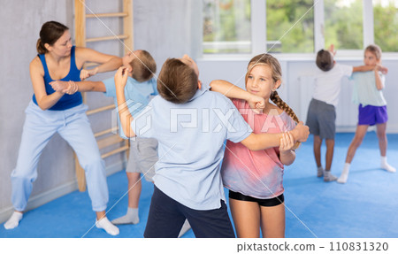 Boys and girls in gym perform basic elements of krav maga self-defense system. 110831320