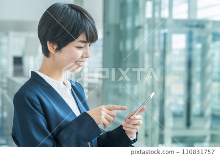 A business woman with a smartphone. A business woman with a smartphone. 110831757