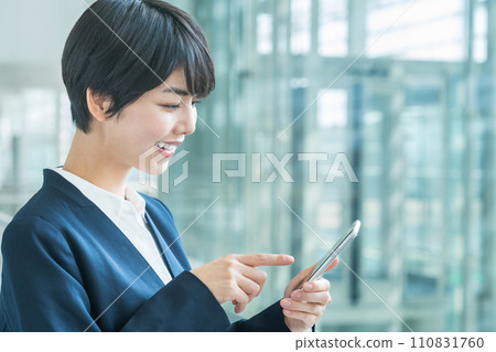 A business woman with a smartphone. A business woman with a smartphone. 110831760