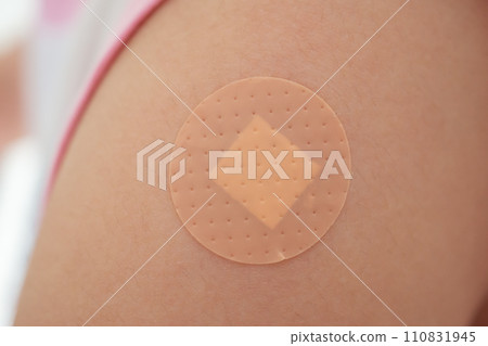 Vaccinated little asian girl with adhesive plaster after vaccine injection Vaccinated little asian girl with adhesive plaster after vaccine injection 110831945