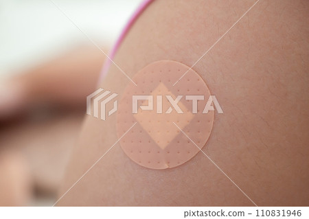 Vaccinated little asian girl with adhesive plaster after vaccine injection Vaccinated little asian girl with adhesive plaster after vaccine injection 110831946