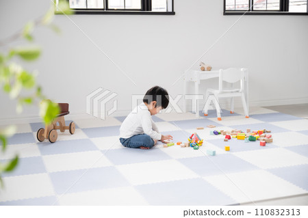 Toddler playing with building blocks Wide angle image of nursery school, kindergarten, room Toddler playing with building blocks Wide angle image of nursery school, kindergarten, room 110832313