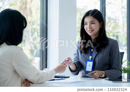 Employees present with mock up credit card payments to business customers. Ready to provide discounts and life insurance Employees present with mock up credit card payments to business customers. Ready to provide discounts and life insurance 110832324
