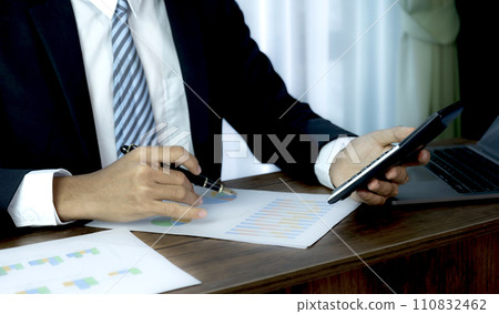 Businessmen bookkeeper hand holding pen and use calculator, laptop analysis the graph for Setting challenging business goals and ready to achieve target at home office Businessmen bookkeeper hand holding pen and use calculator, laptop analysis the graph for Setting challenging business goals and ready to achieve target at home office 110832462