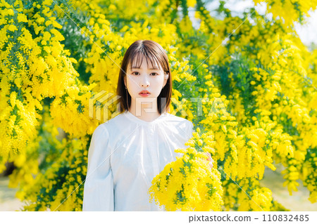 被含羞草花包圍的年輕女子 110832485