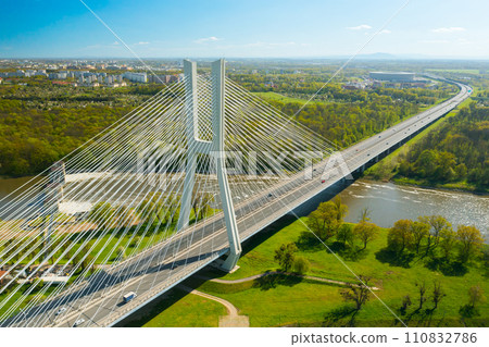 A lengthy pylon bridge extends across the Oder River, casting its shadow in the sunny city of Wroclaw 110832786