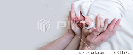 banner. Mom and dad hands hold small legs of their two newborn twin babies banner. Mom and dad hands hold small legs of their two newborn twin babies 110833572