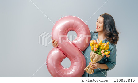 woman with flowers and balloon in shape of eight 110833819