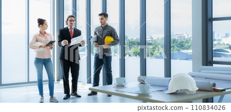 Engineer team meeting to inspect the construction blueprint drawings, work plan and distribute work before starting the building Engineer team meeting to inspect the construction blueprint drawings, work plan and distribute work before starting the building 110834026