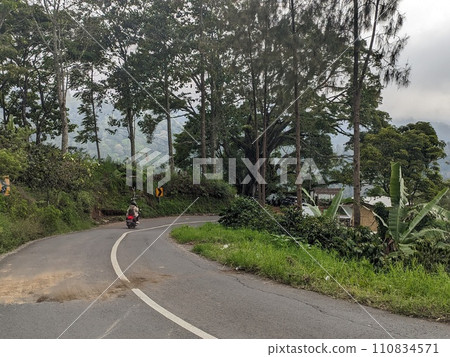The road is in the middle of forests and mountains which are cloudy and cool The road is in the middle of forests and mountains which are cloudy and cool 110834571