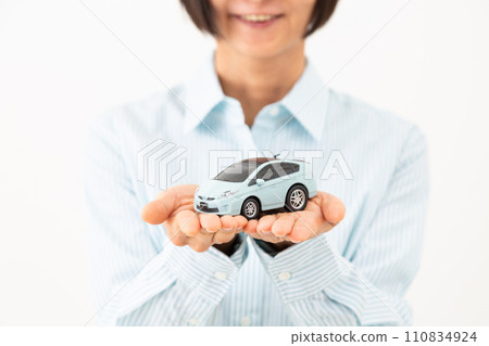 一位中年婦女拿著汽車模型微笑 一位中年婦女拿著汽車模型微笑 110834924
